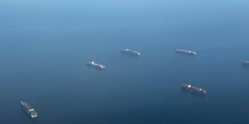 Five cargo ships sailing across the Panama Canal.